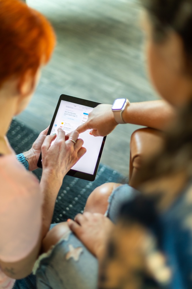 Two people looking over a tablet together.